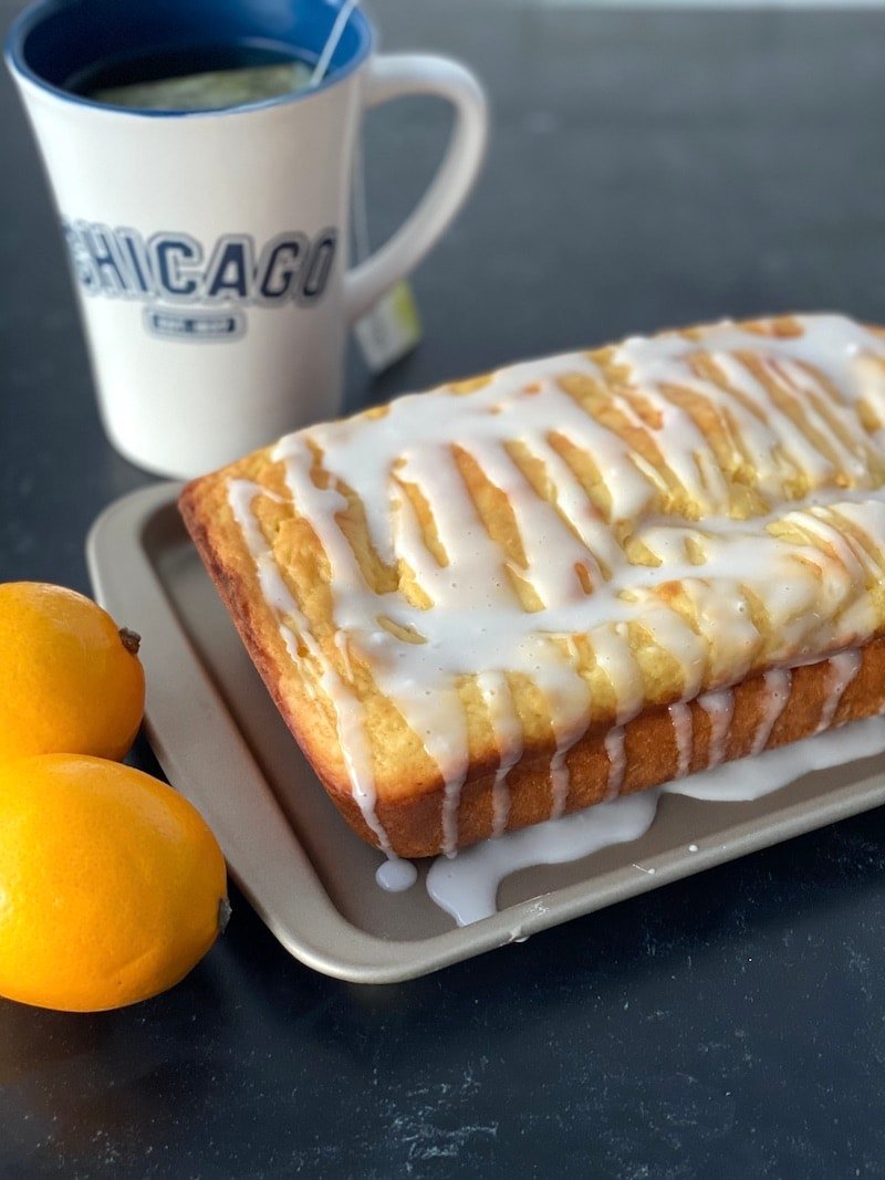 this is a photo of lemon loaf bread with a cup of hot tea