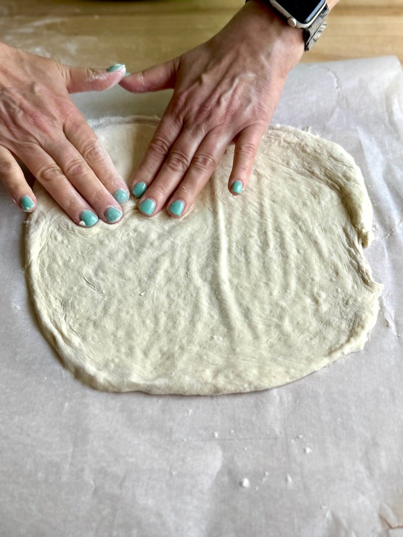 shaping pizza dough with hands