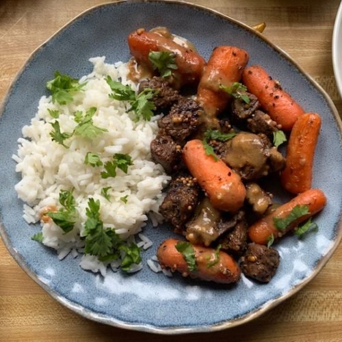 this is a photo of braised beef with carrots and rice