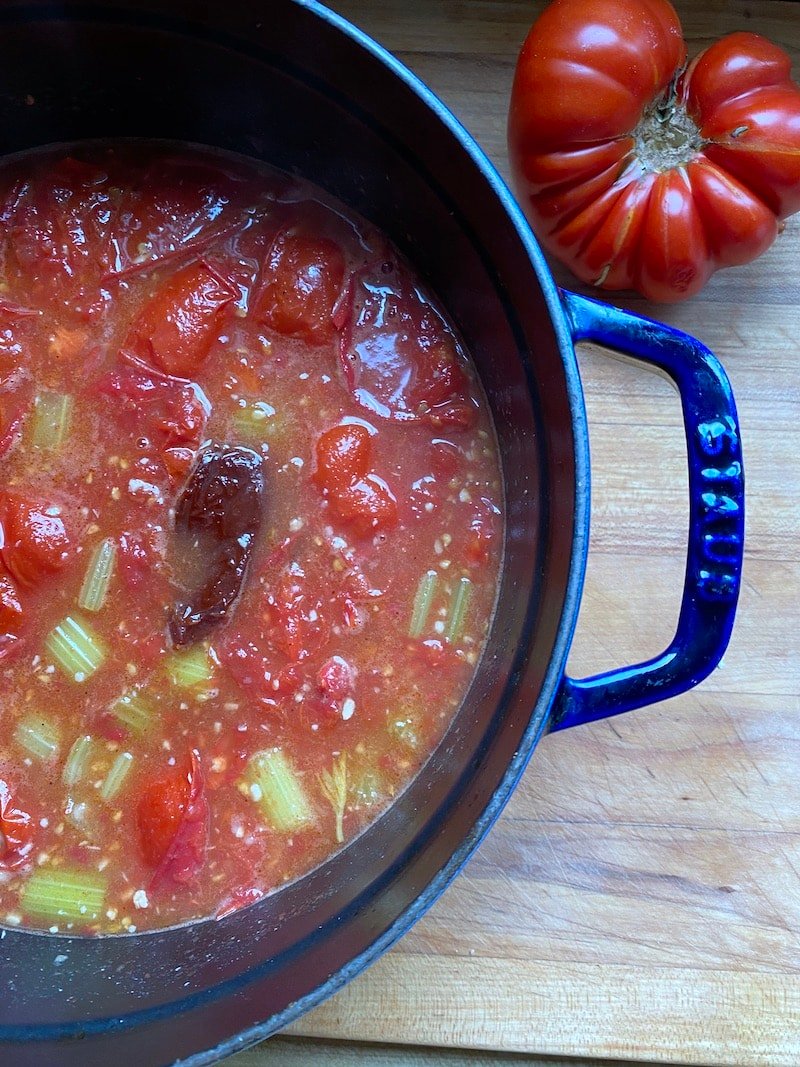 this is a pot of tomatoes, celery, carrots and chipotle pepper in a stock pot