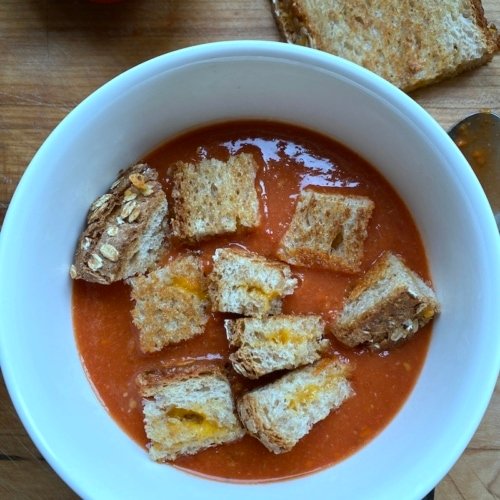 this is a picture of tomato soup with grilled cheese croutons