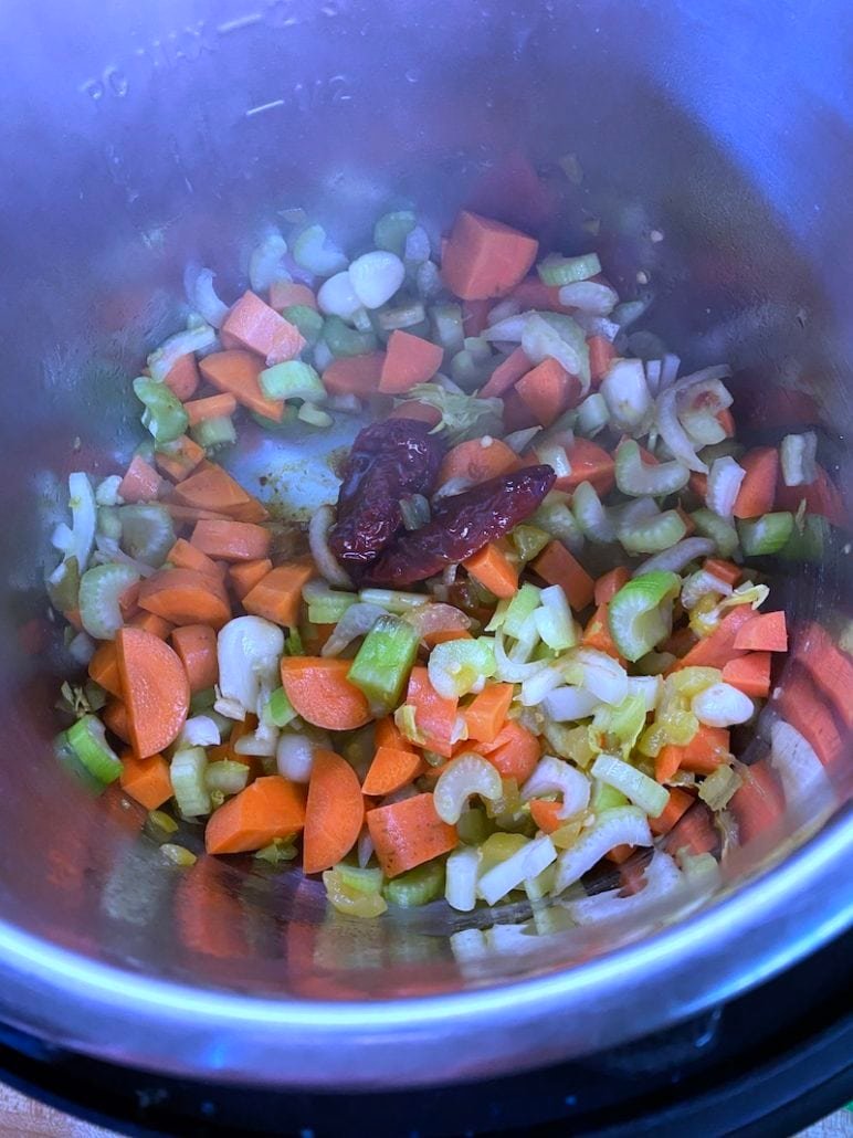 this is a photo of vegetables sauting as the base of black bean soup