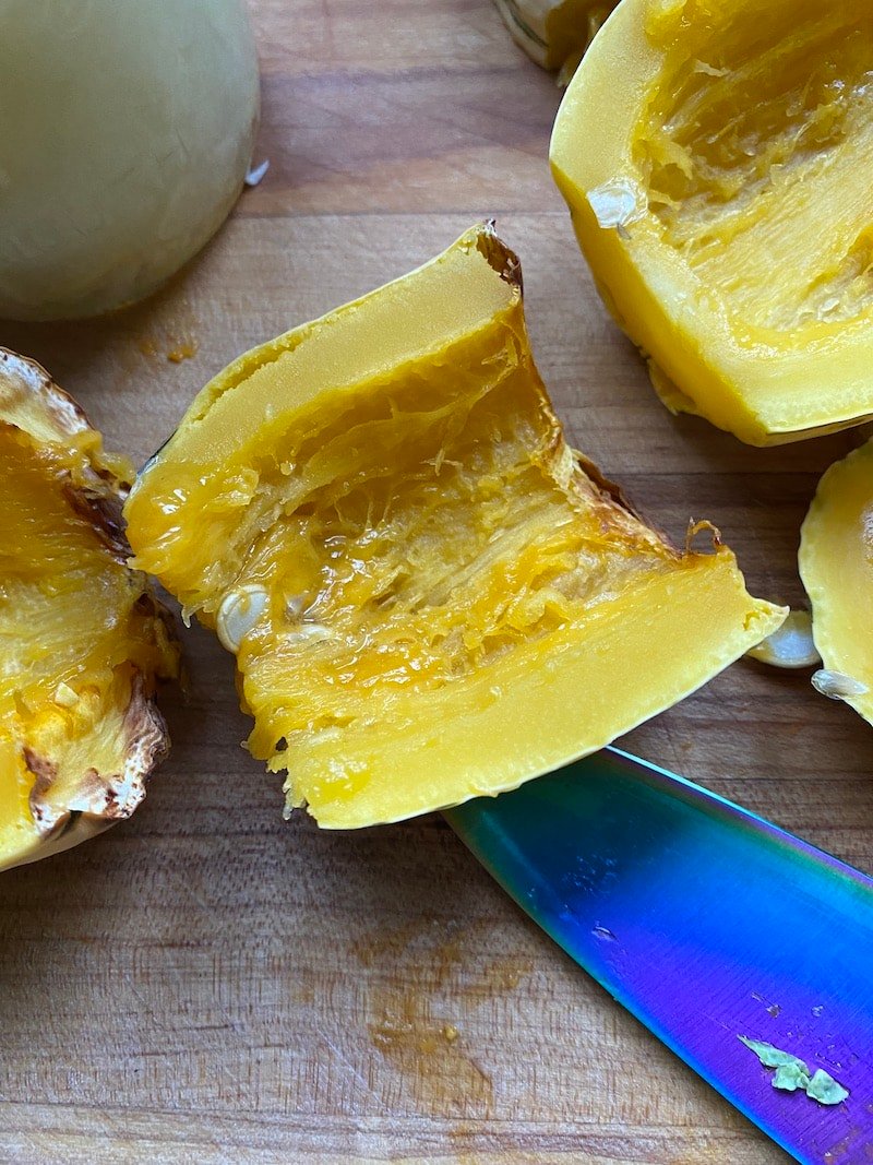 this is a picture of roasted delicata squash cut in half on a cutting board