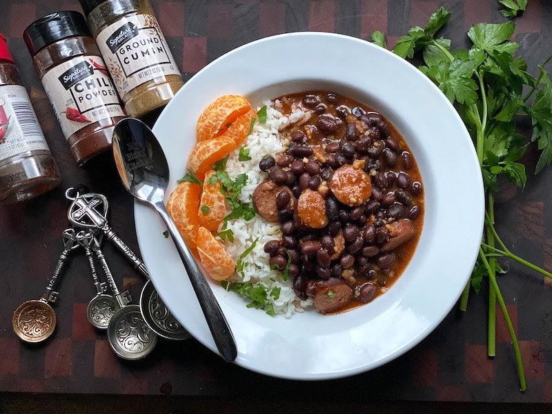 this is a bowl of black beans and sausage over white rice