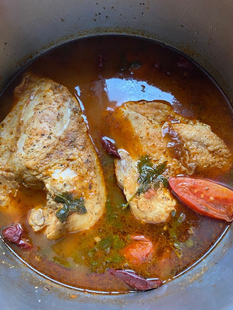 this is a photo of chicken in birria broth