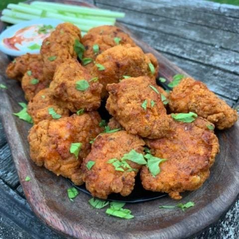 blackened popcorn chicken on a plate with celery