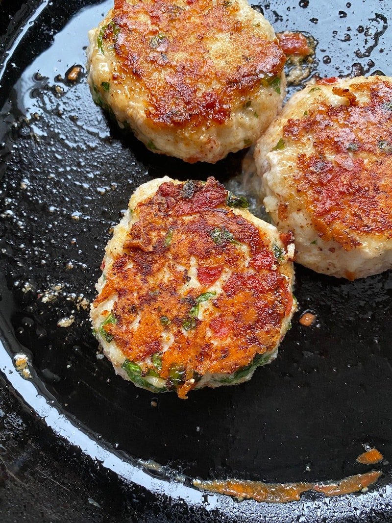 this is a photo of turkey burgers in a cast iron skillet