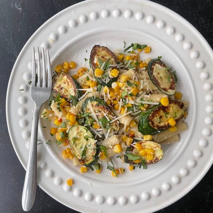 this is a plate of creamy pasta with charred zucchini and corn
