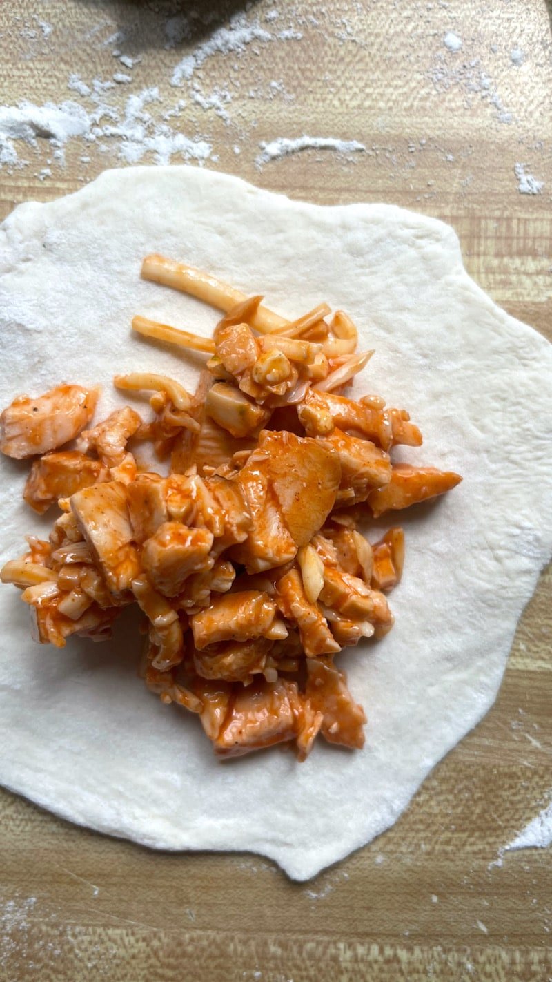 this is a photo of buffalo chicken bomb filling inside skinny pizza dough