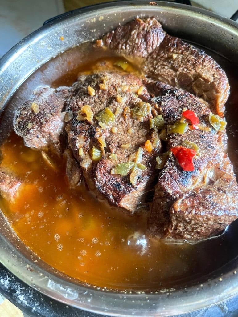 this is a photo of chuck roast in an instant pot ready to make french dip sandwiches