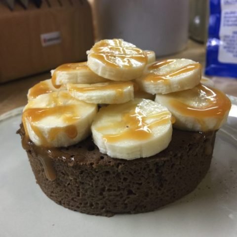 this is a photo of a microwave chocolate cake covered with caramel sauce and sliced bananas