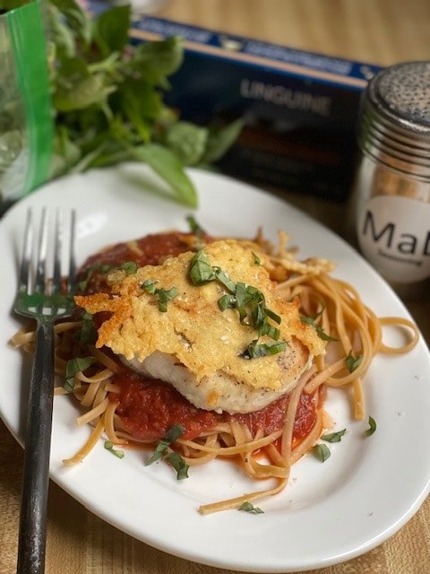 This is a photo of crispy chicken parmesan over whole wheat pasta