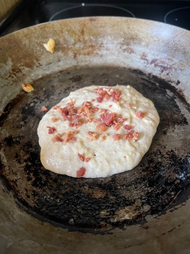 This is a photo of bacon bits on top of delicata squash pancake batter