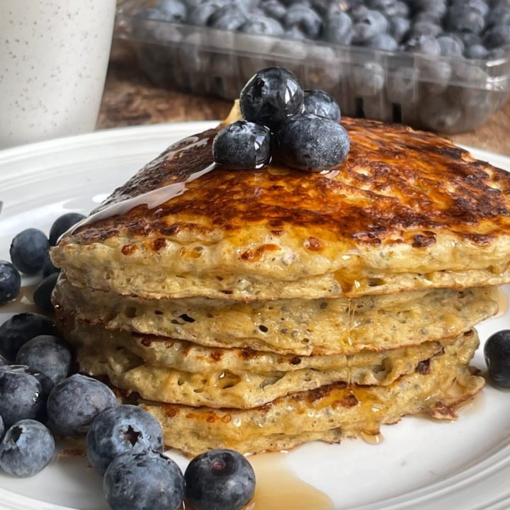 This is a photo of chia seed blender pancakes with blueberries and syrup.