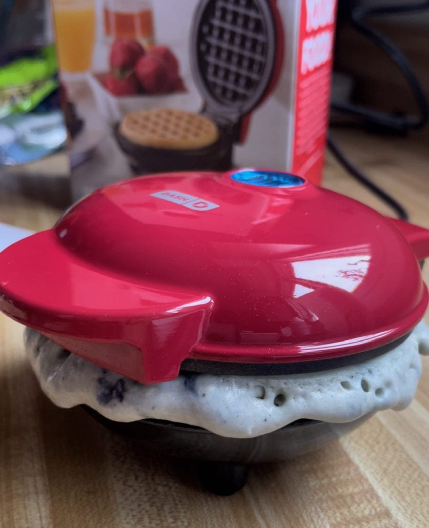 this is a photo of a waffle maker overfilled with batter