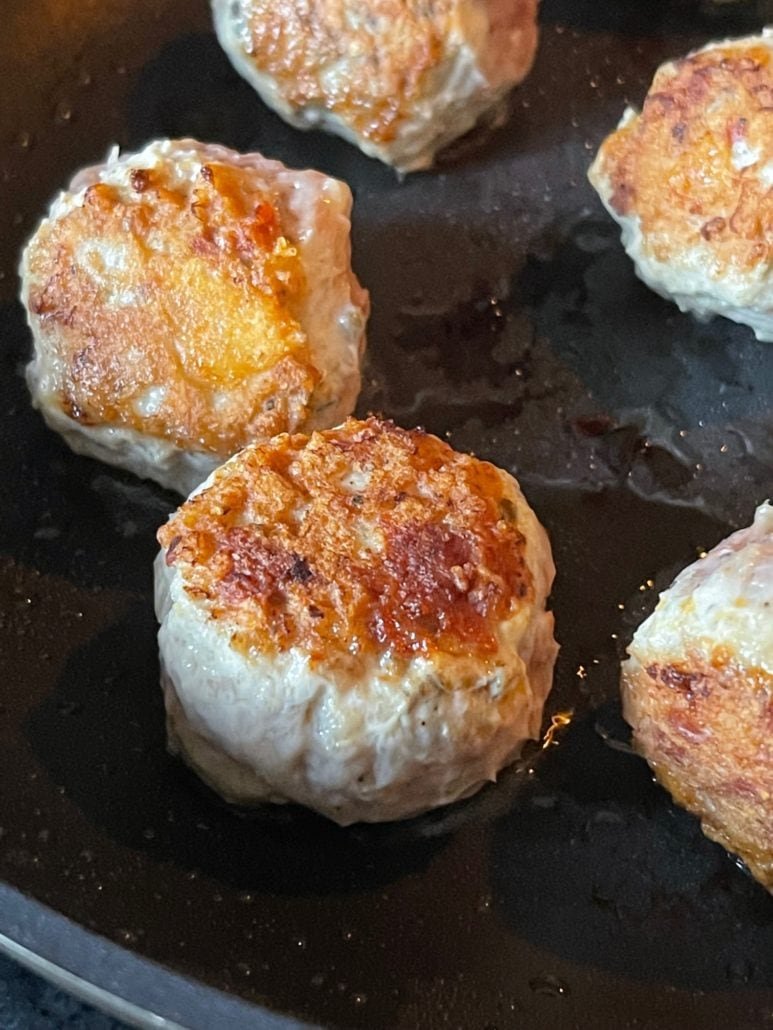 this is a photo of seared meatballs in a frying pan