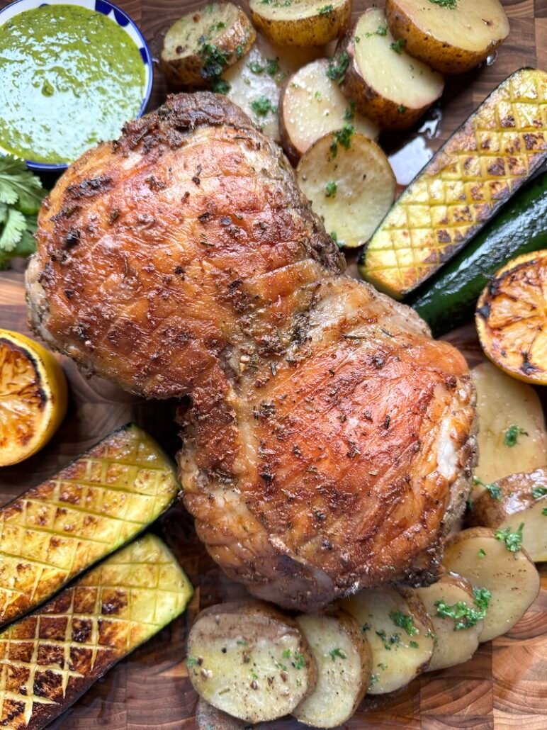 this is a roasted leg of lamb with idaho potatoes and zucchini