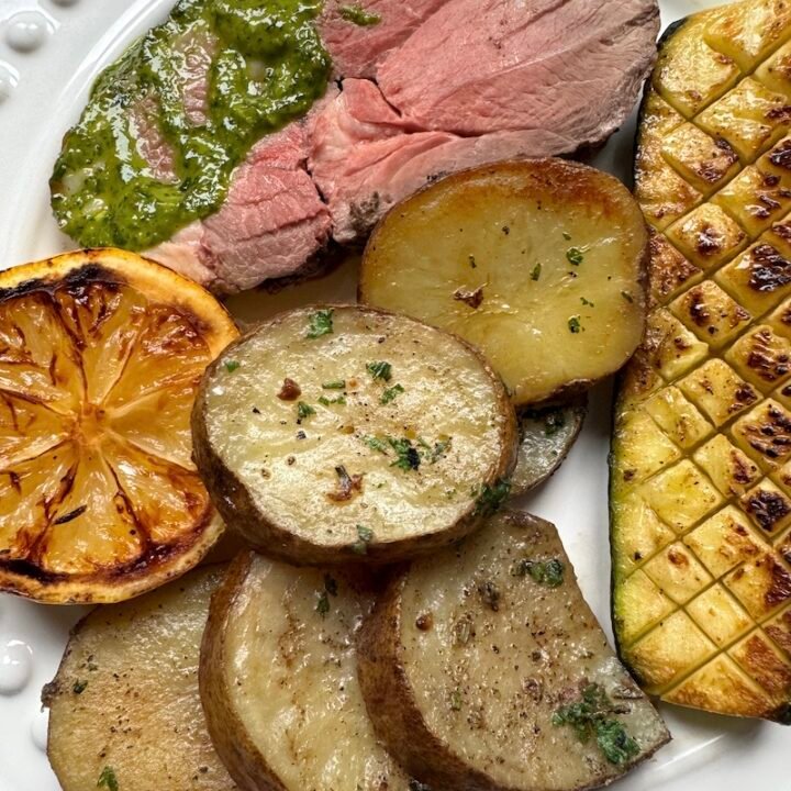 this is a plate of boneless leg of lamb with Idaho potatoes