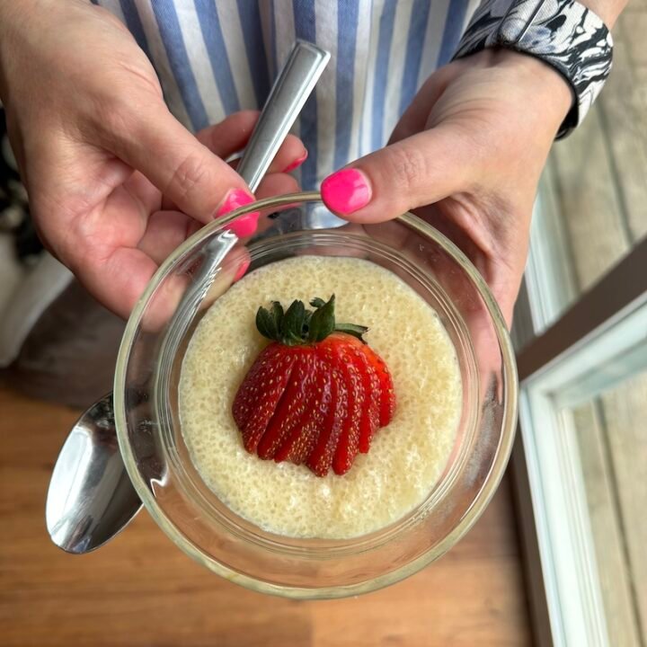 this is a bowl of tapioca pudding with a strawberry garnish