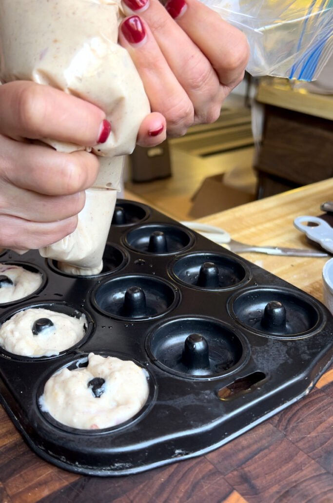 piping donut batter into do