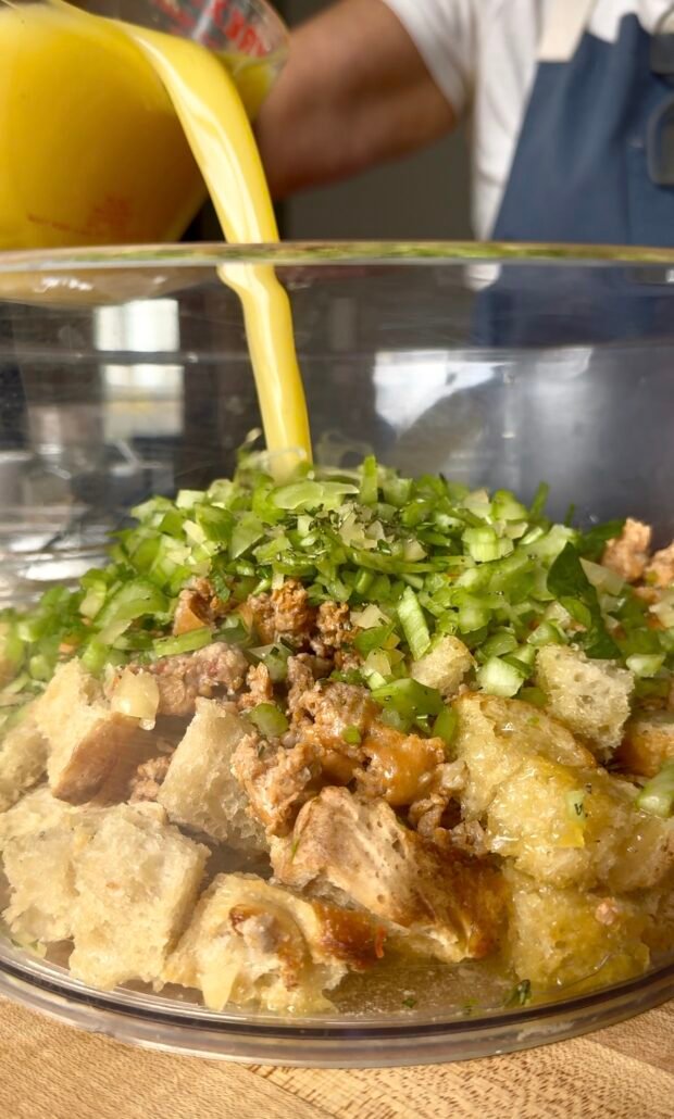 broth being added to sourdough sausage stuffing