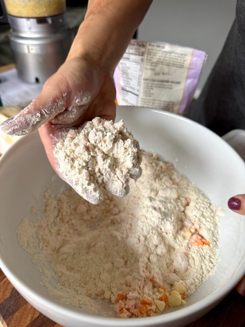 this is a bowl of flour where cheese and butter are being incorporated to make scones