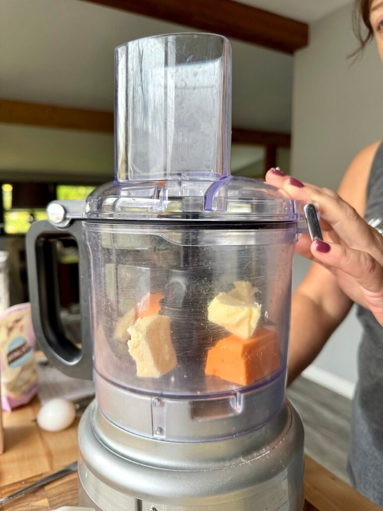 butter and cheese being crumbled in a food processor for scones