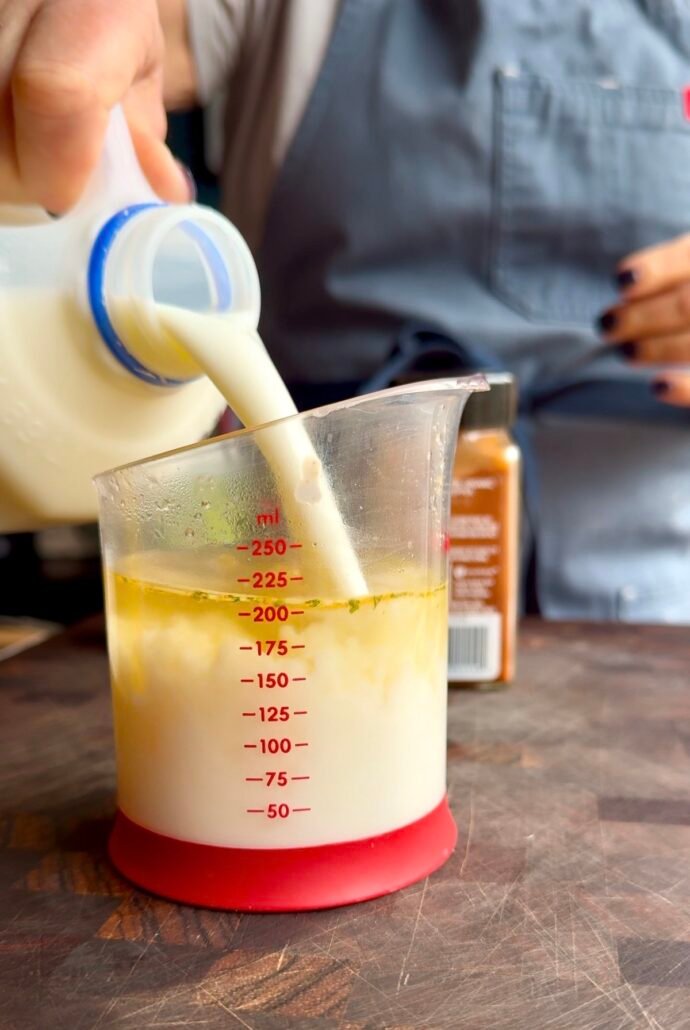 adding milk to chicken broth to make creamy pasta