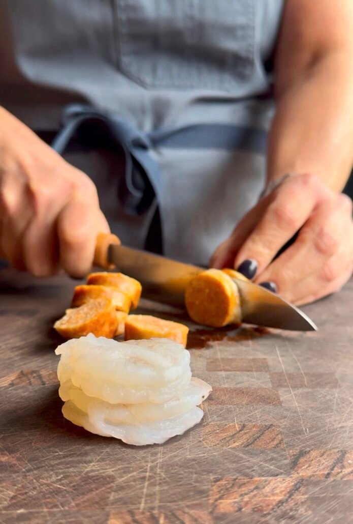 this is sausage and shrimp being sliced for pasta - the chicken sausage and shrimp are low weight watchers points