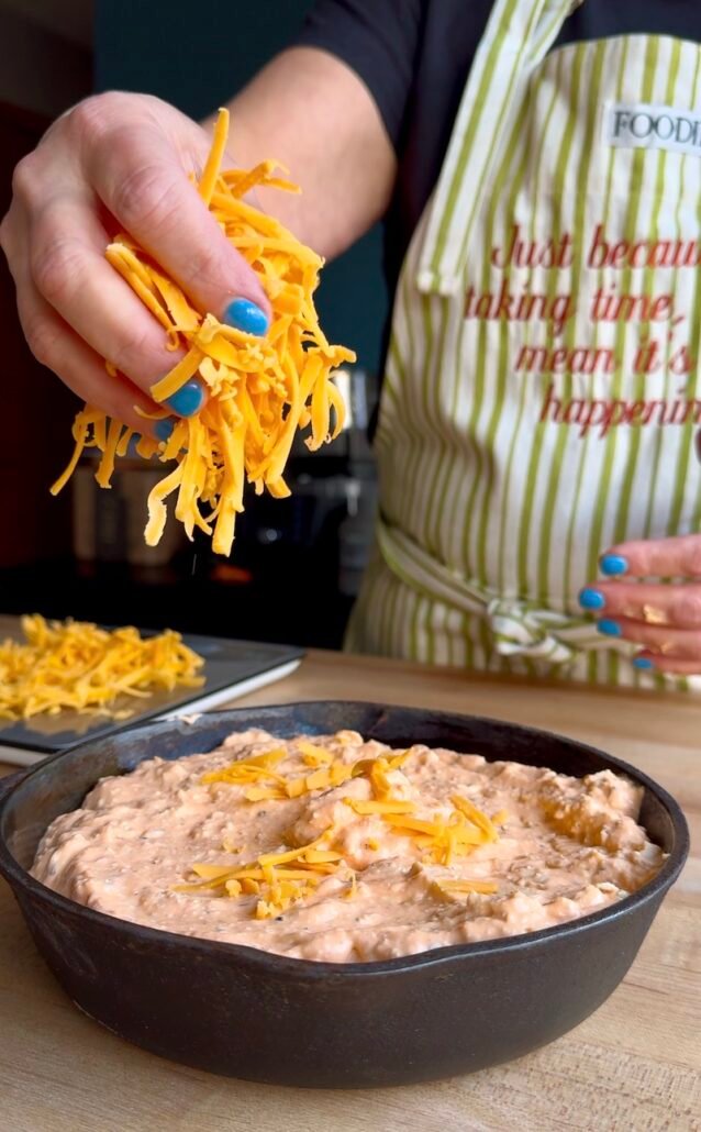 adding sharp cheddar cheese to buffalo chicken dip