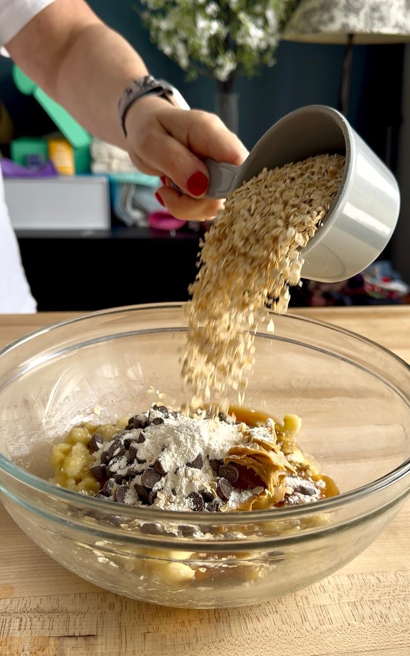 this is a bowl of banana bars where oats are being added to the batter