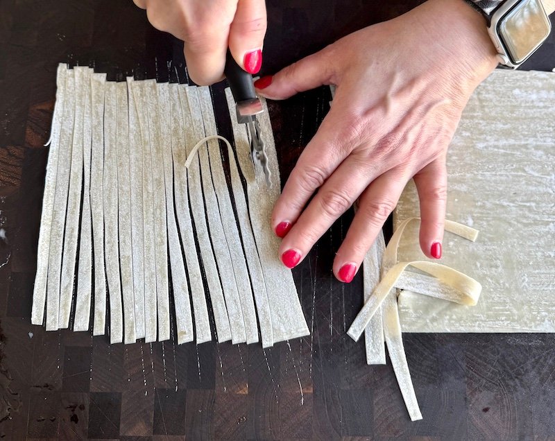 cutting egg roll wrappers to make shrimp wontons