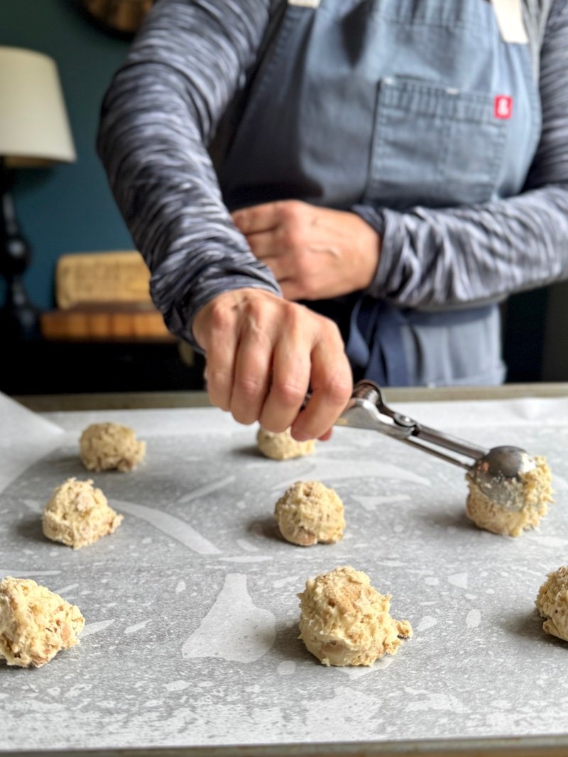 scooping out the cookies on a baking sheet