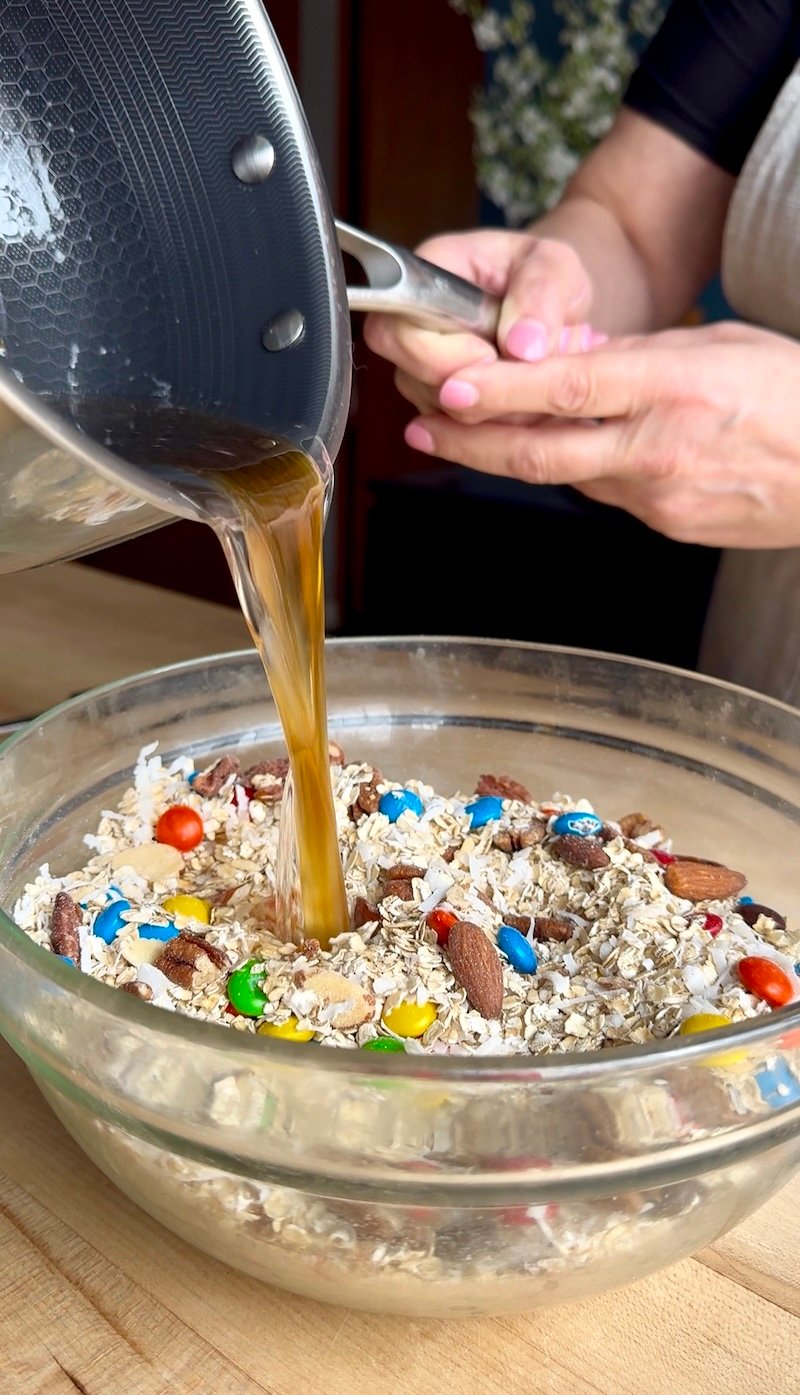 pouring liquid into dry mix for trail mix granola