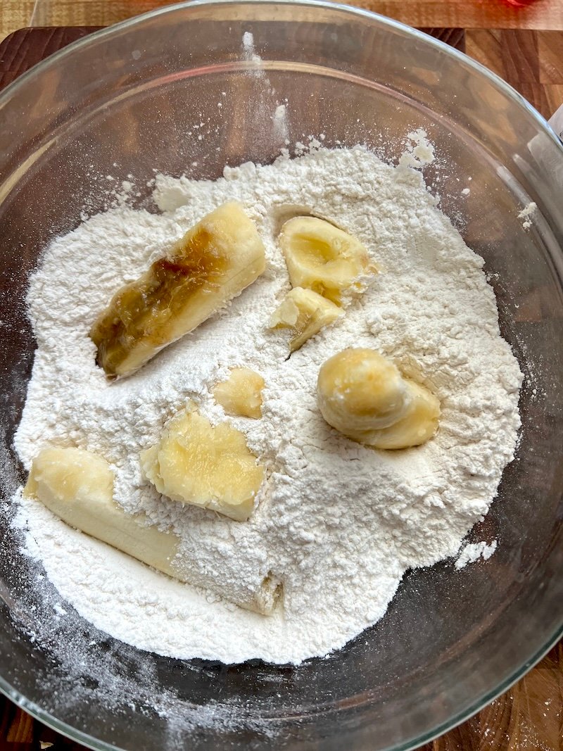 adding banana to biscuit dough