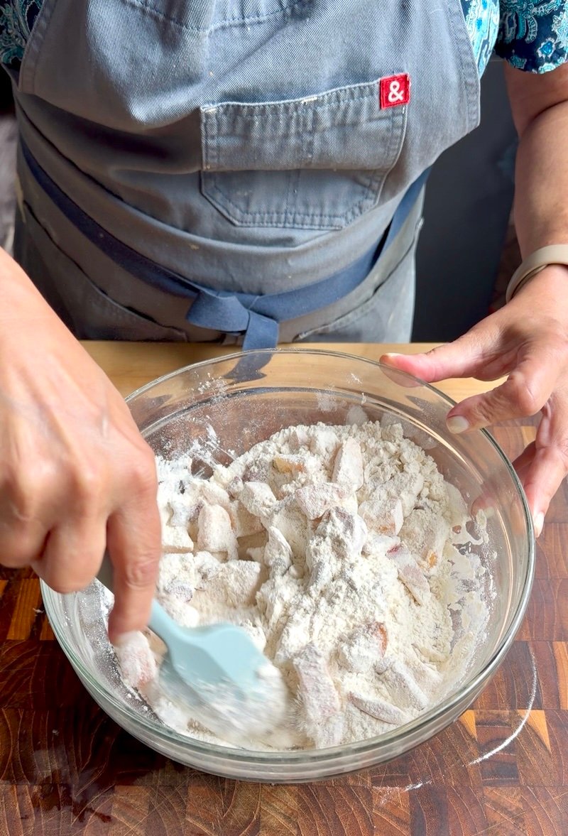 mixing peaches into biscuit dough