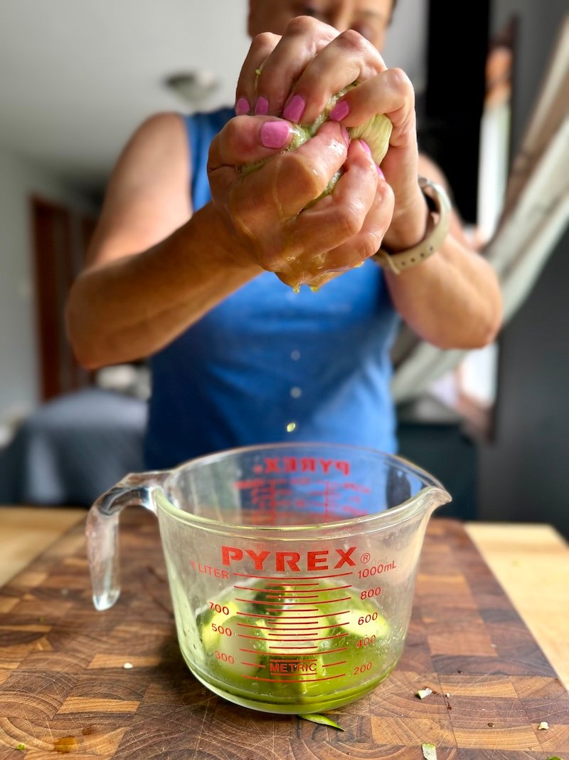 squeezing out liquid from shredded zucchini